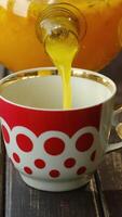 Vertical . Tea party. Pouring sea buckthorn tea from teapot video
