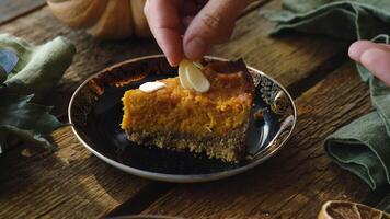 Sprinkle slice of pumpkin pie with chopped almonds. Making homemade traditional American thanksgiving pie video