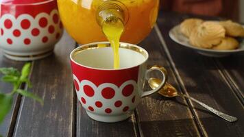 Tea party. Pouring sea buckthorn tea into mug video