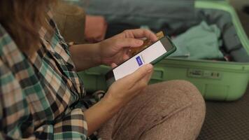 Online payment for last minute tour. Woman booking a hotel using credit card and smartphone video