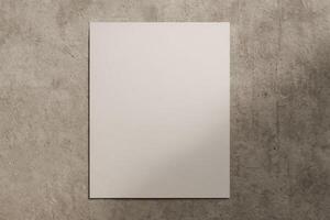Vertical blank paper poster mockup on textured concrete wall with natural light and shadow for artwork or print presentation photo