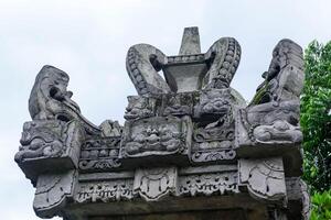 Detail of traditional Balinese temple stone carvings with sacred ornamentation, showcasing cultural and spiritual architecture from Bali, Indonesia. photo