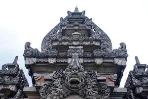 Front view of a traditional Balinese Hindu temple gate with intricate stone carvings and sacred symbolism in Bali, Indonesia. photo