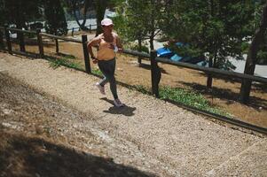 Young Woman Jogging on an Outdoor Path Surrounded by Nature photo