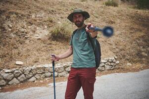 Male Hiker Exploring Trail with Trekking Stick in Nature photo