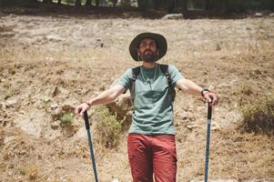 Hiker with Trekking Poles Enjoying a Scenic Mountain Trail Adventure in Nature photo