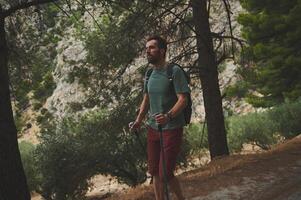 Male Hiker Enjoying Nature While Walking Through a Scenic Mountain Trail photo