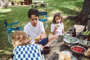 Family Enjoying a Picnic Outdoors with Fresh Food in a Mountain Setting photo