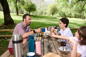 Family Enjoying Picnic in Scenic Mountain Setting Surrounded by Nature photo