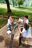 Family Enjoying a Picnic in a Scenic Outdoor Mountain Setting photo