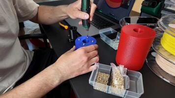 Caucasian male assembling a 3D printed model with tools, showcasing DIY, innovation, and craftsmanship video