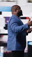 Vertical African american public speaker discussing with audience about social media platforms, dynamic screens for entertainment and web communication. Networking advice for engagement. Camera A. video