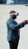 vertical africano americano programador noivando dentro virtual realidade com uma fone de ouvido, concentrando em sistema desenvolvimento. utilizando código em terminal janela para depurar e Projeto Novo Programas. isto carreira. Câmera uma. video