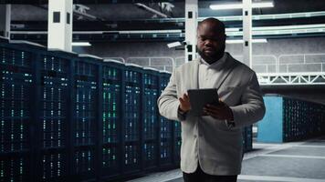 Server farm employee upgrading gear for increased processing and storage capacity. Data center IT professional ensuring error free and scalable networks for intense computational demands, camera A video