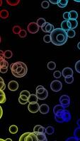 Abstract flying colorful bubbles on black background. float straight up quickly. video