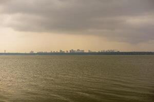 Dramatic sky behind the lake with cityscape in the background photo