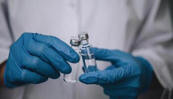 Person Holding Vaccine Vials in Blue Gloves for Cold Chain Management photo