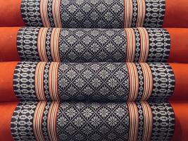 A stack of orange and black pillows photo