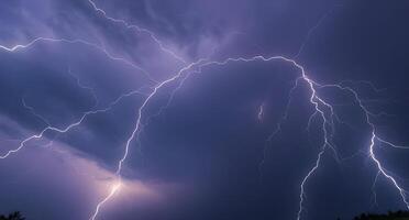 Lightning strikes over a dark sky with trees in the background photo
