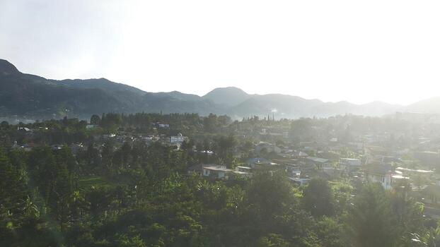 A view of a town in the mountains with the sun shining photo