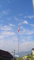 A flag pole with a red and white flag photo