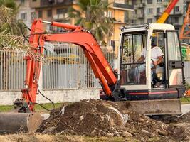 Excavator Operator at Work in Urban Construction Scene photo