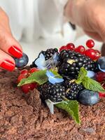Decorative Chocolate Cake Topped with Fresh Berries and Mint, Mid-Garnish photo