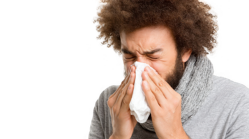 Sick young man sneezing into tissue with transparent background png