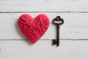 Yarn Heart and Antique Key on White Wood Love and Unlock photo