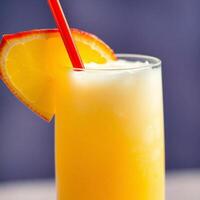 Refreshing citrus cocktail with an orange slice and red straw. Perfect for a summer day or a relaxing evening. photo