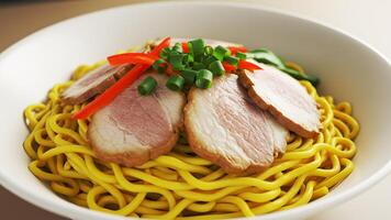 Close-up of Delicious Yellow Noodles with Pork and Vegetables photo