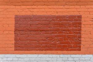 A dark red triangle is painted on a red brick wall. A fancy background for the inscription. photo