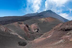 Etna volcano view with colorful black and red hilly terrain in foreground photo