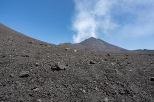 Etna volcano view from the bottom with rocks in foreground photo
