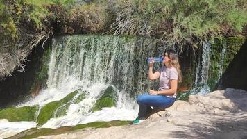Relaxing by a tranquil waterfall in Spain while enjoying refreshing water on a sunny day photo