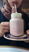 Enjoying a delicious milkshake with toppings at a cafe video