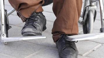 Man using wheelchair on city pavement in daytime video
