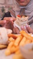 Enjoying delicious wrap with fries at a cozy cafe video