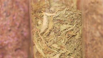 Explore dried tea in clear containers that highlight their textures video