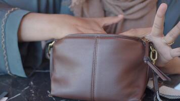 Searching for essentials in a brown crossbody bag video