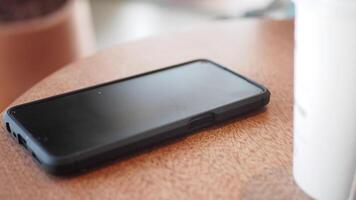 person hand pick smartphone at a wooden table in a cafe video