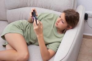 Child playing on mobile phone while slouching, showing poor posture in comfortable living room setting photo