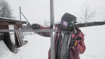 A skilled welder works on a metal framework outdoors in snowy weather, showcasing their craftsmanship photo