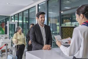 smiling businessman in suit standing at counter,waiting attendant,screening boarding pass at gates before entrance to airplane photo