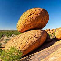 Two large rocks sitting on top of each other in the desert photo