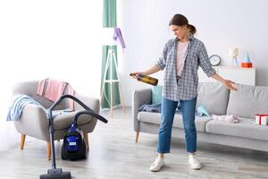 Disgusted millennial lady standing in messy flat after party, not willing to do cleanup, empty space. Sickened female student at dirty college dorm room after celebration, garbage lying everywhere photo