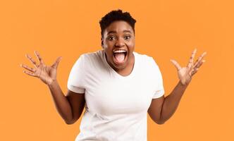 Joyful Plus-Size African Woman Screaming In Excitement Holding Hands Near Face Posing Looking At Camera On Yellow Background In Studio. Positive Emotion, Omg, Unexpected Joyful Surprise Concept photo