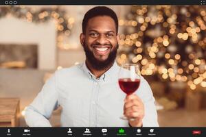 Stay Safe At Home, Social Distancing, Isolation. Cheerful happy black man skyping on computer, having romantic online date with his partner, holding glass of red wine and toasting, monitor view photo