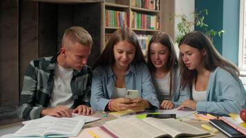 Four happy smiling teenagers gadget addicted celebrate online winning carefree girl playing mobile phone group classmates support education problem overuse internet gaming pupils in school library video