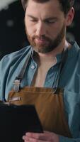 Caucasian man working in factory roasted coffee beans male inspector check roaster machine quality roasting control writing checklist notes guy business owner caffeine roasting production industry video